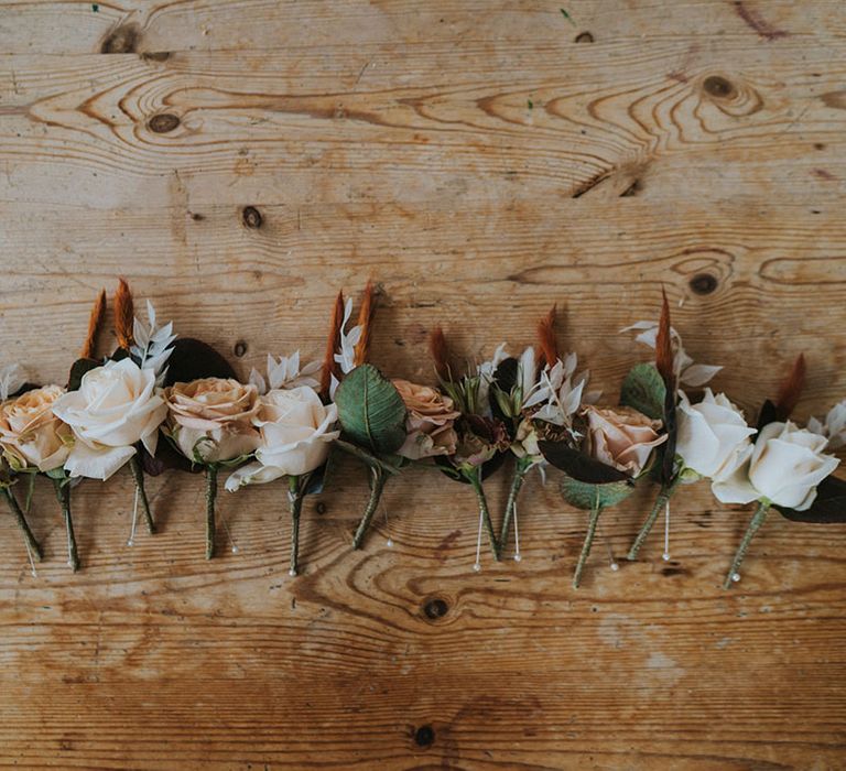 Different colour rose buttonholes for the groomsmen