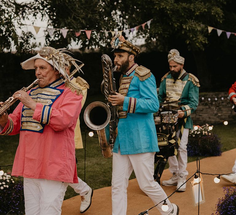 Live wedding band in colourful outfits and different hats play their instruments