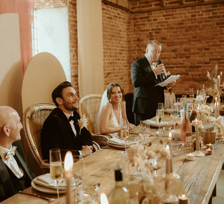 Father of the bride makes a speech as the other attendees listen