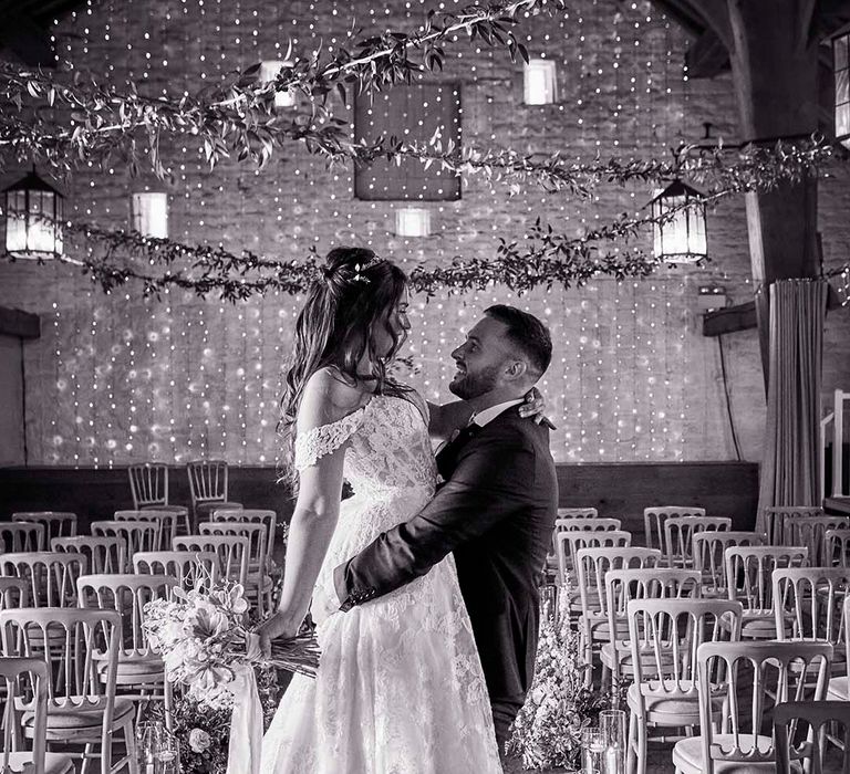 East Riddlesden Hall wedding venue with fairy light backdrop, greenery garlands and pillar candles lining the aisle 