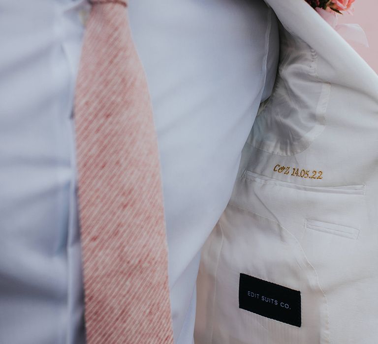 Bride with personalised embroidered suit jacket with the date of the wedding 