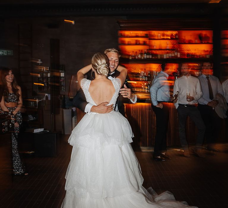 Bride wears open back Eva Lendal wedding dress and dances with her groom on their wedding day