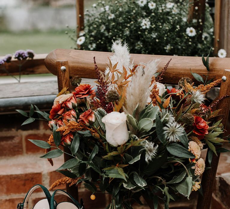 Dark green velvet platform wedding shoes with a orange autumnal wedding bouquet with dried grass