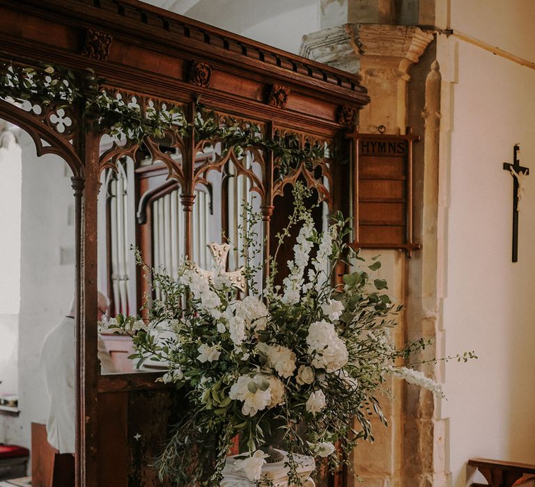 White wedding flowers decorate the church for a classic and traditional style day 