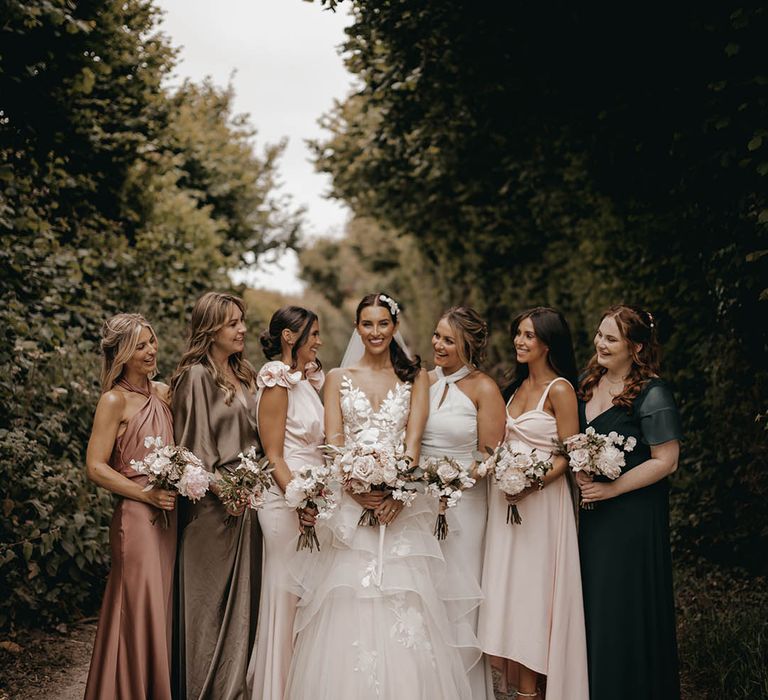 Bridesmaids in different colour and different style bridesmaid dresses with the bride in a Wtoo by Watters wedding dress 