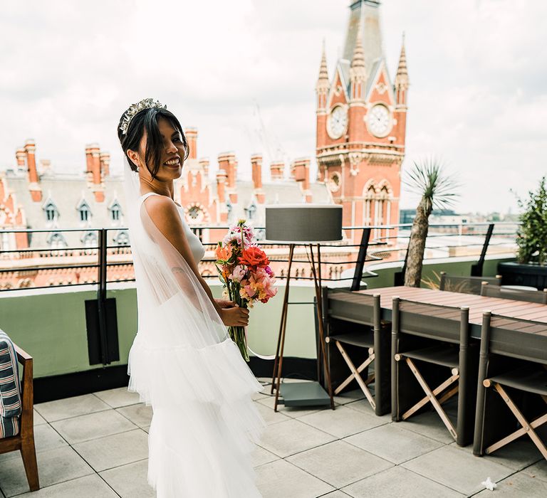 East Asian bride wears ruffled veil and fitted open back wedding dress with scallop lace edging 