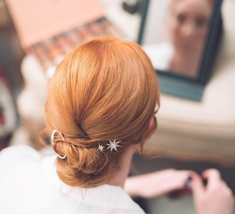 Bridesmaid with light red hair styled in an updo with a celestial moon and stars hair clip with sparkles 