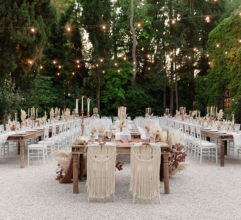 Outdoor boho destination wedding reception with neutral styling and macrame decor 