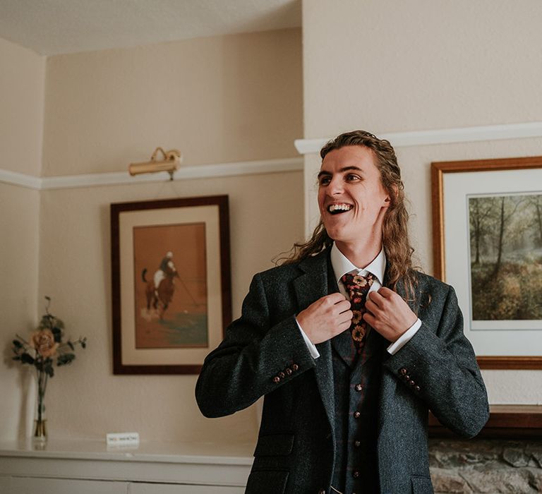 Groom in dark grey three piece suit and burgundy flower patterned tie 