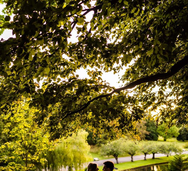 The bride and groom posing together for a cute couple portrait at their glasshouse wedding 