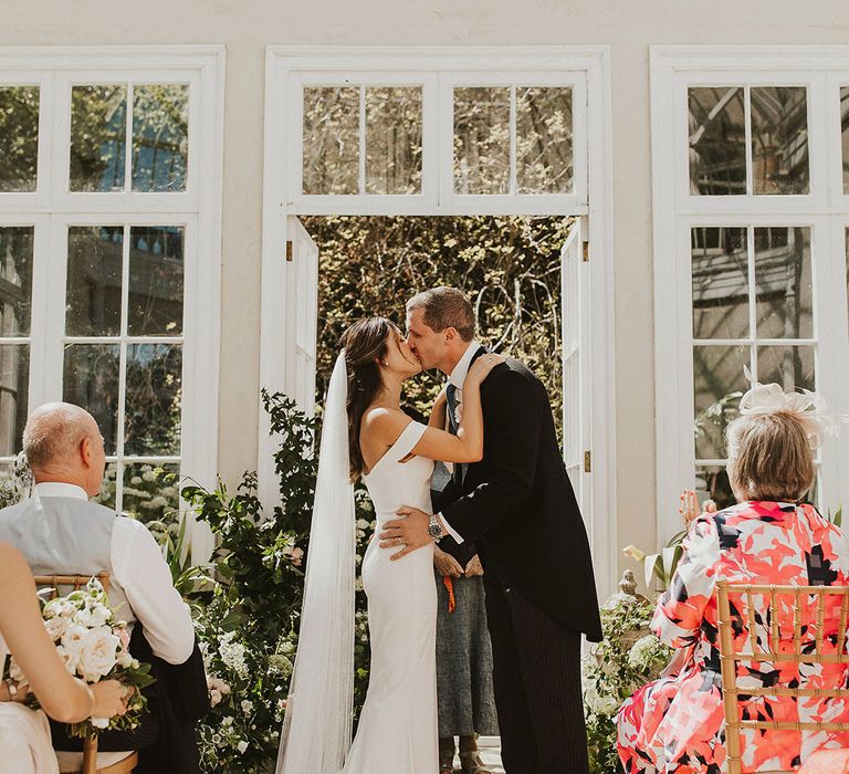 The bride and groom share their first kiss at the altar at Came House in Devon | Steph Newton Photography