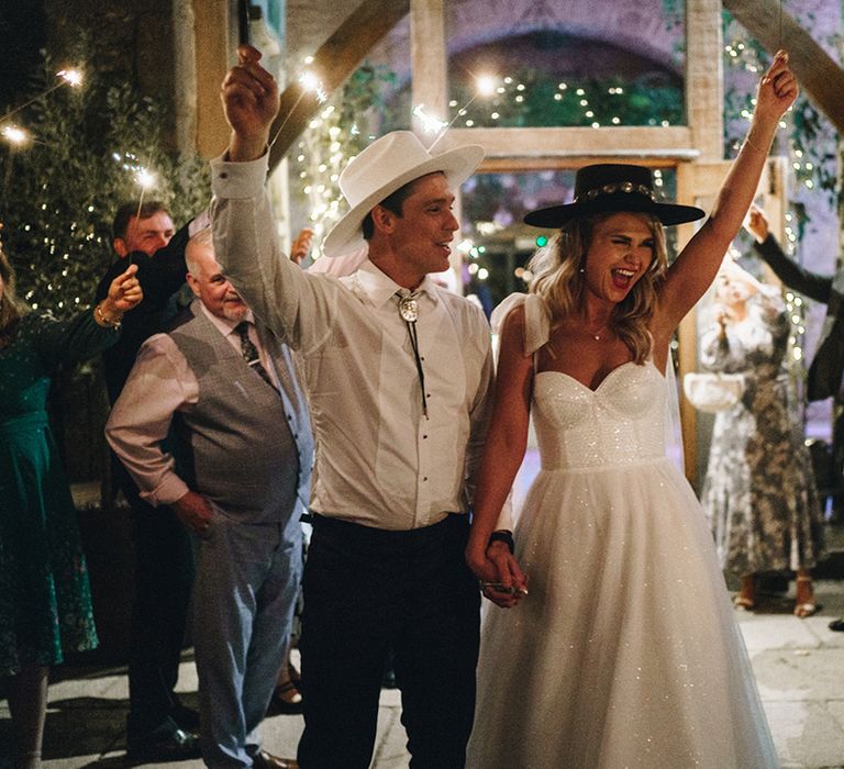 Sparkler send off for bride and groom wearing cowboy hats at their country theme wedding day at Stone Barn 