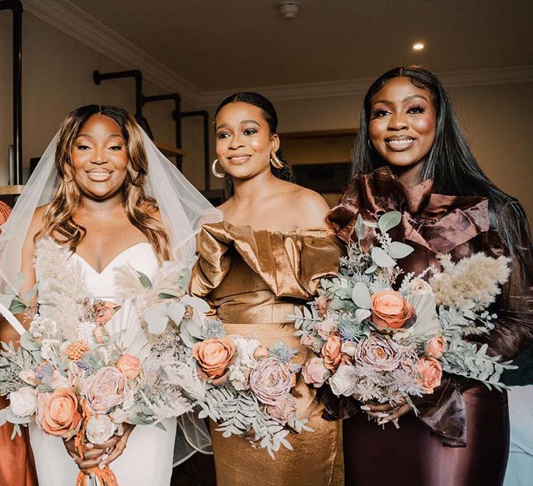 The bride and her bridal party hold large oversized bouquets with roses and more 