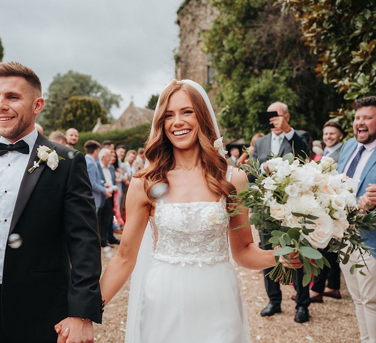 The bride and groom exit their wedding ceremony to bubbles instead of confetti 