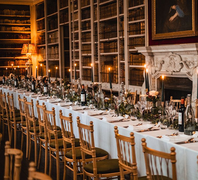 Cosy library at St Giles House for Christmas wedding decorated with candlelight and red and green theme decor 