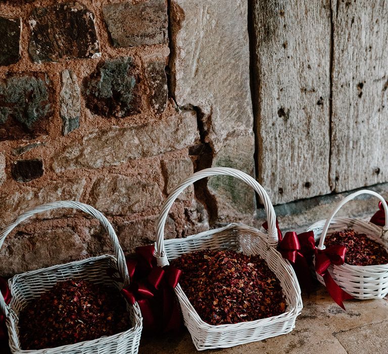 White wicker baskets full of dried petals for confetti 