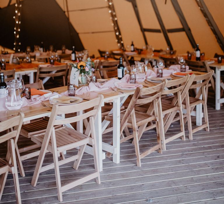 Tipi wedding with a pink and white wedding theme and simple minimalist wedding decorations with sunflowers 