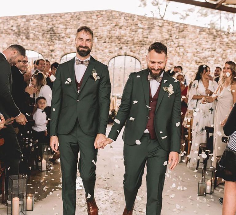 Gay wedding ceremony with two grooms wearing dark green wedding suits and brown leather shoes 