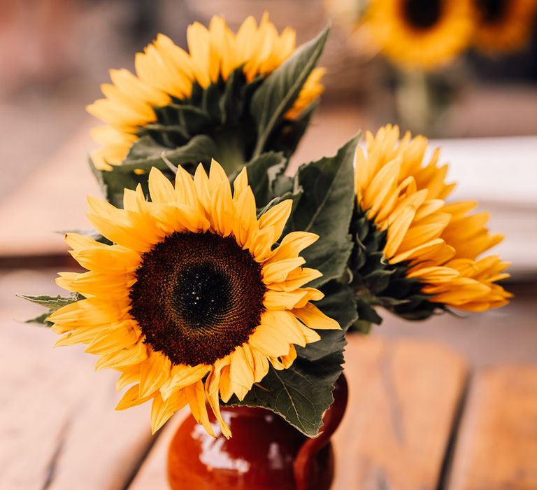 Small vases filled with sunflowers for the wedding table decorations 