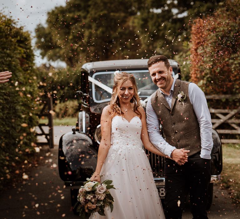 Bride and groom portrait next to their vintage wedding car 