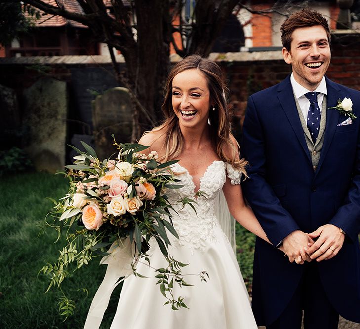 Newly wed couple at barn wedding with off the shoulder wedding dress 