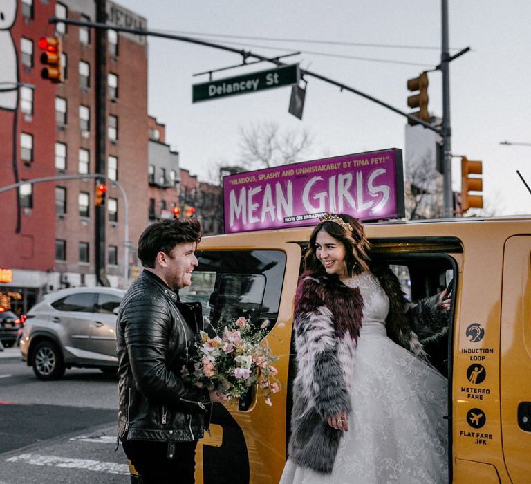 Bride & groom get into yellow taxi in wedding clothes