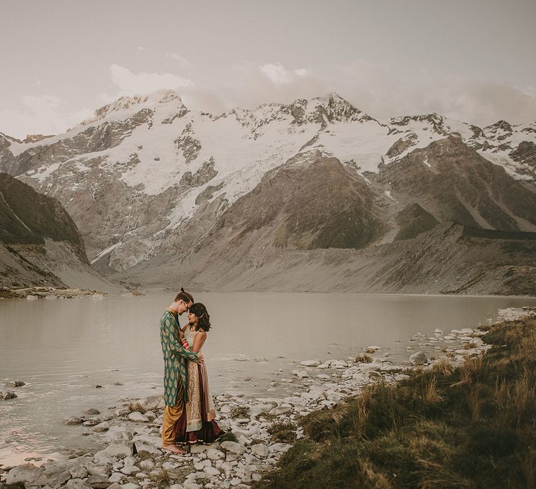 The bride and groom embrace by the lakes of Mount Cook, New Zealand