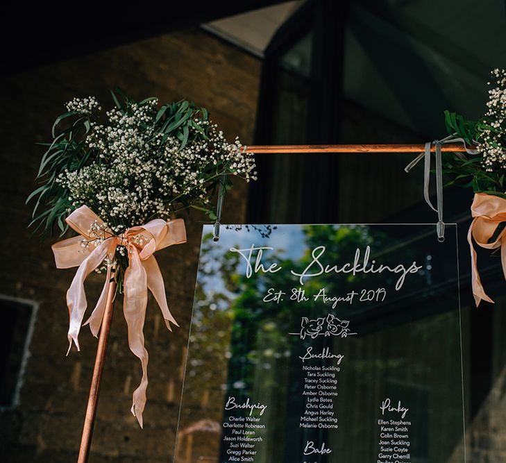 Acrylic seating plan with rose gold frame and pink bows for barn wedding