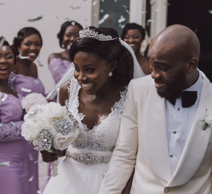 A Black bride and groom exit their wedding to confetti.