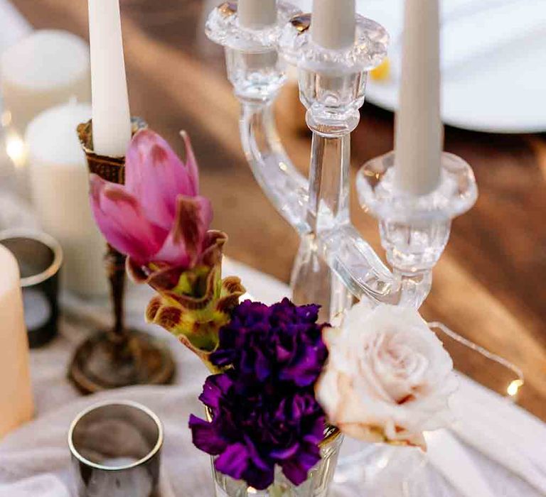 Pink and purple wedding flower table decor with candles