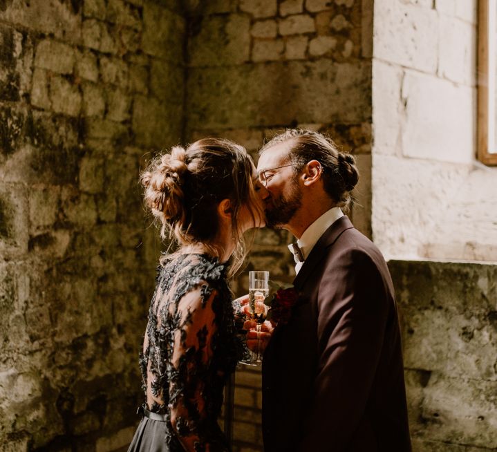 Bride and groom kissing at their gothic style wedding 