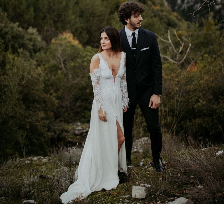 The bride and groom in front of a forest and hillscape