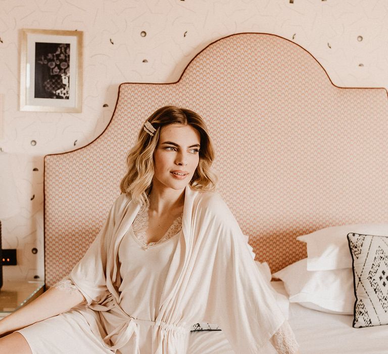 The bride in a peach coloured hotel room at Amadria Park Hotel, wearing a bridal dressing gown and slip dress by Lisca Lingerie