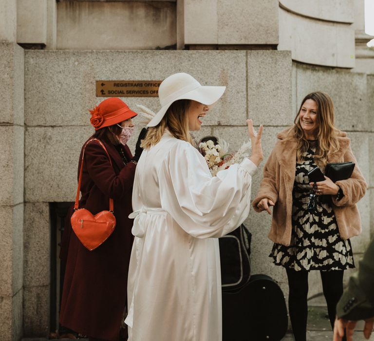 Bride greets wedding guests outdoors