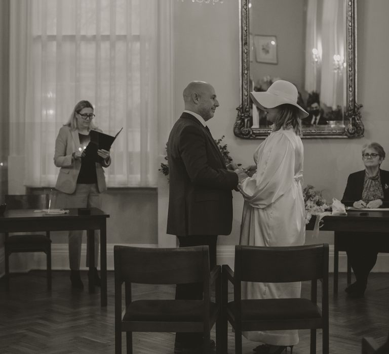 Black & white image of bride & groom during wedding ceremony