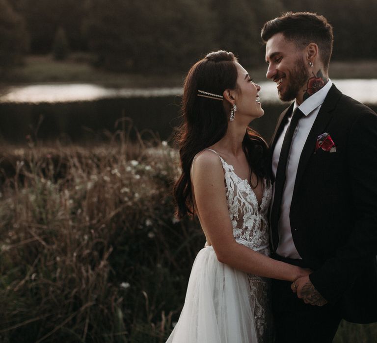 Bride and groom by the lake for a moody romantic wedding shoot