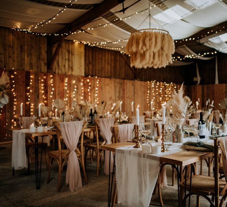 Boho wedding styled reception with fairy lights, candles, drapes and a pampas grass chandelier 