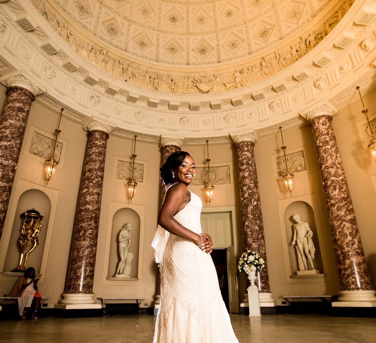 Bride stands in beautifully lit room on her wedding day