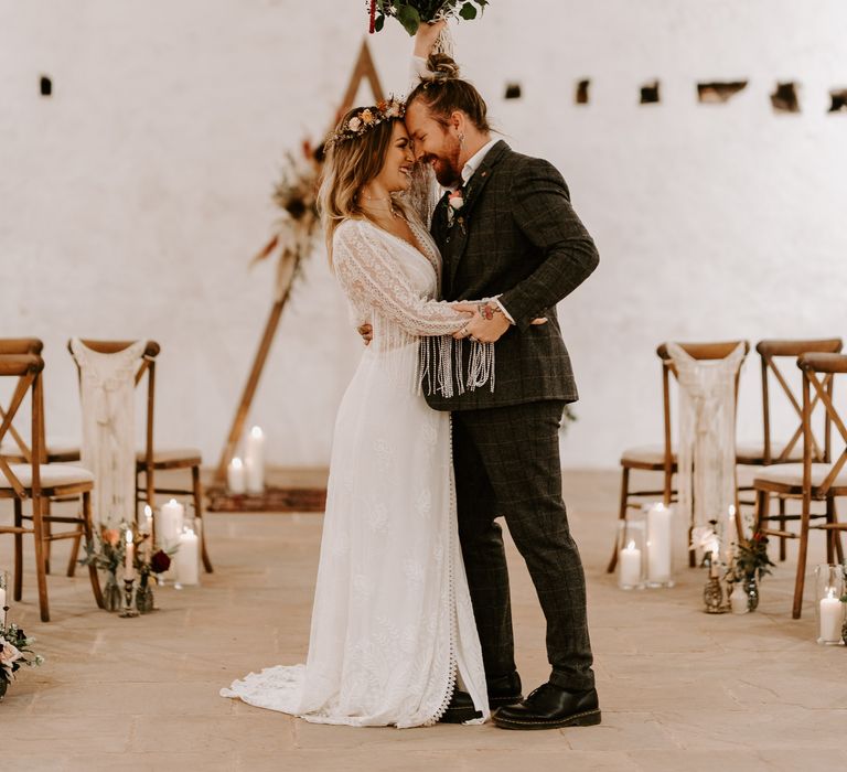 Bride in fringe sleeve wedding dress with groom at boho wedding