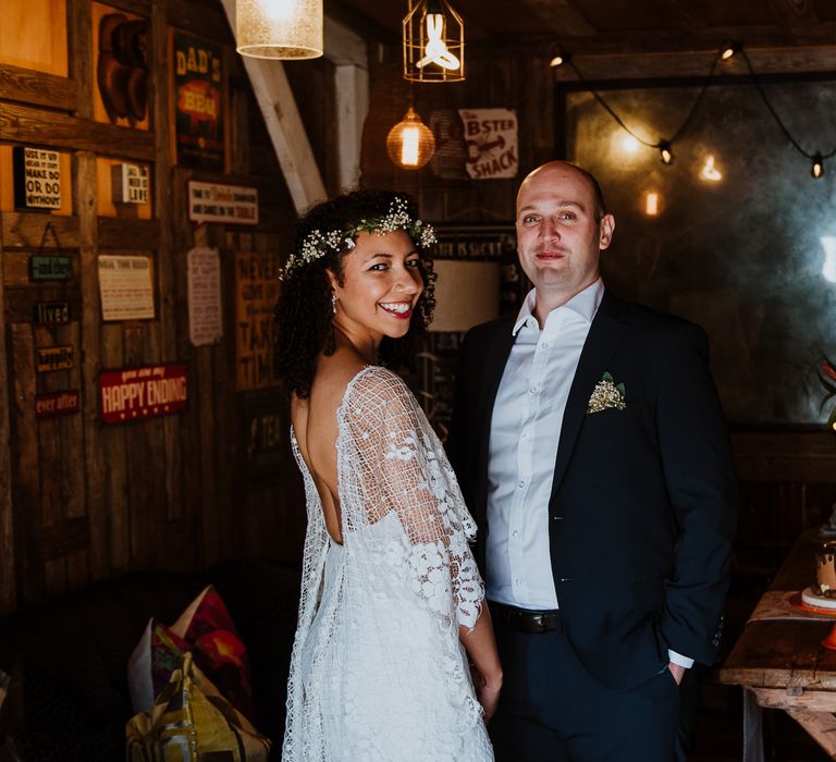 Bride & groom look toward camera after wedding ceremony as bride wears her hair naturally and with simple floral crown