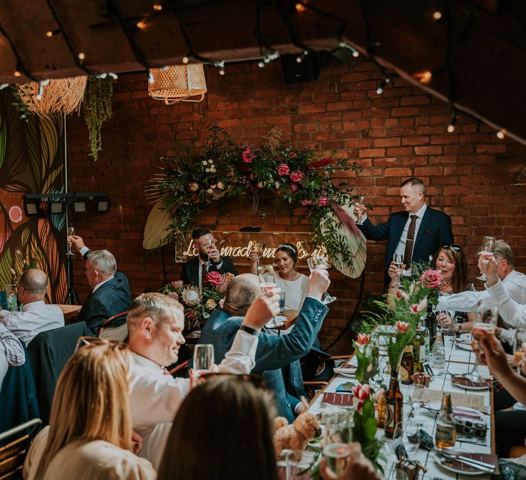 Wedding party raise their glasses during speeches at reception party at the Horticulture Bar