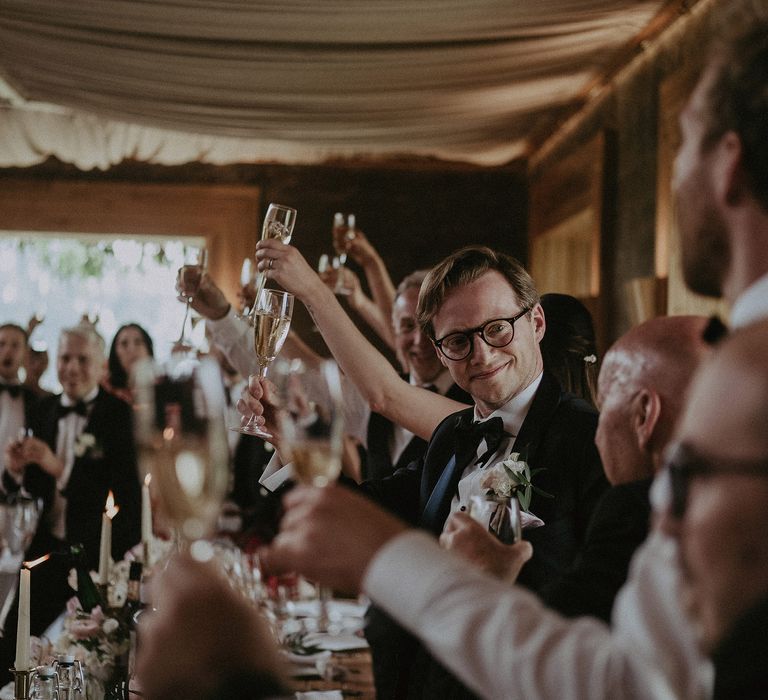 Wedding reception party raise their glasses at Elmore Court for classic wedding