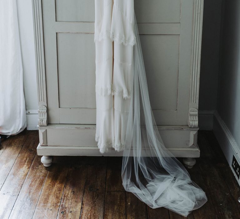 Wedding gown from Whistles hangs on coat hanger before wedding ceremony