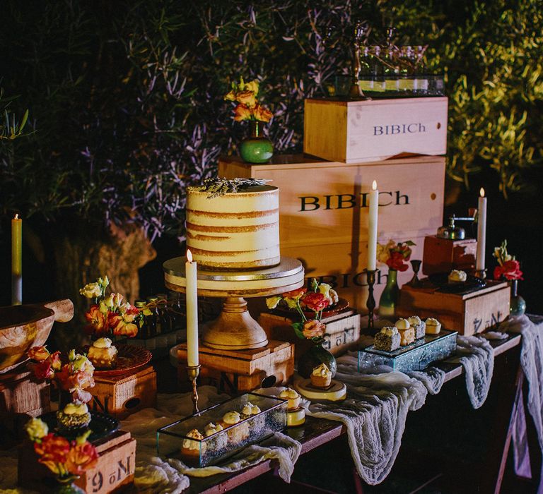 Outdoor dessert table complete with naked wedding cake and rustic wooden boxes