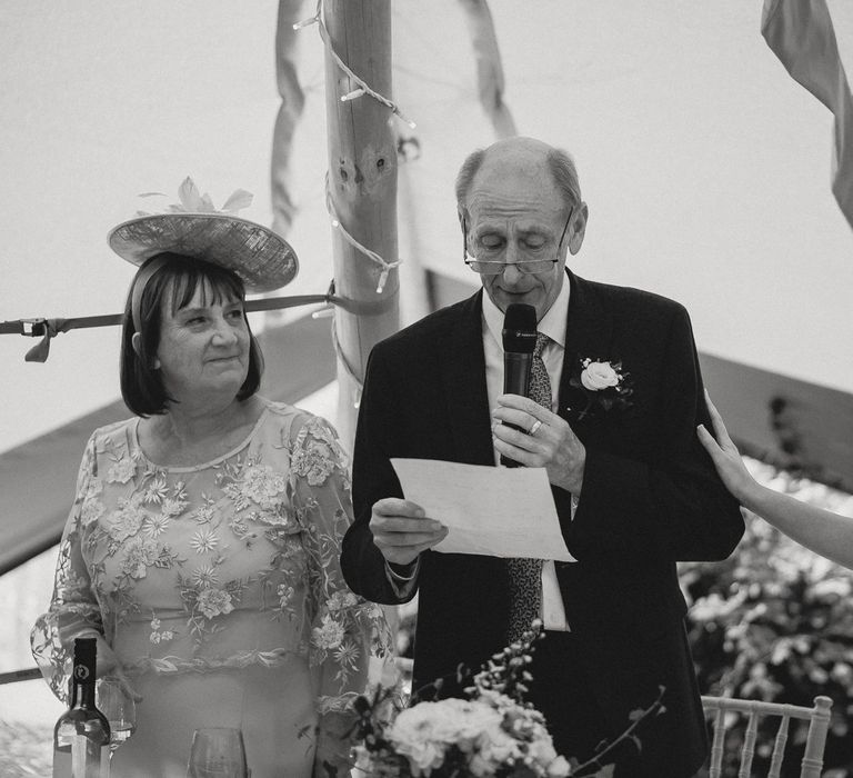 Father of the bride makes speech whilst at top table with bride and guests during tipi wedding breakfast at Inkersall Grange Farm wedding