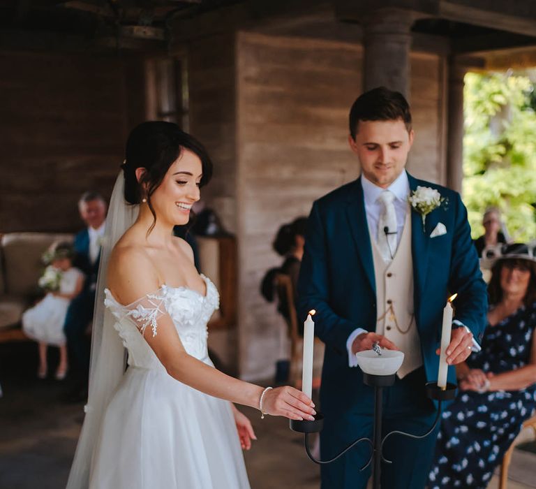 Bride & groom hold candles during their wedding ceremony 