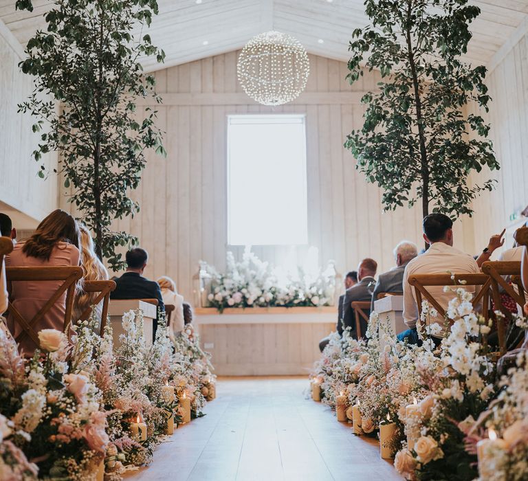 Wedding barn ceremony room at Primrose Hill Farm with flower lined aisle, trees and whitewashed walls for summer wedding