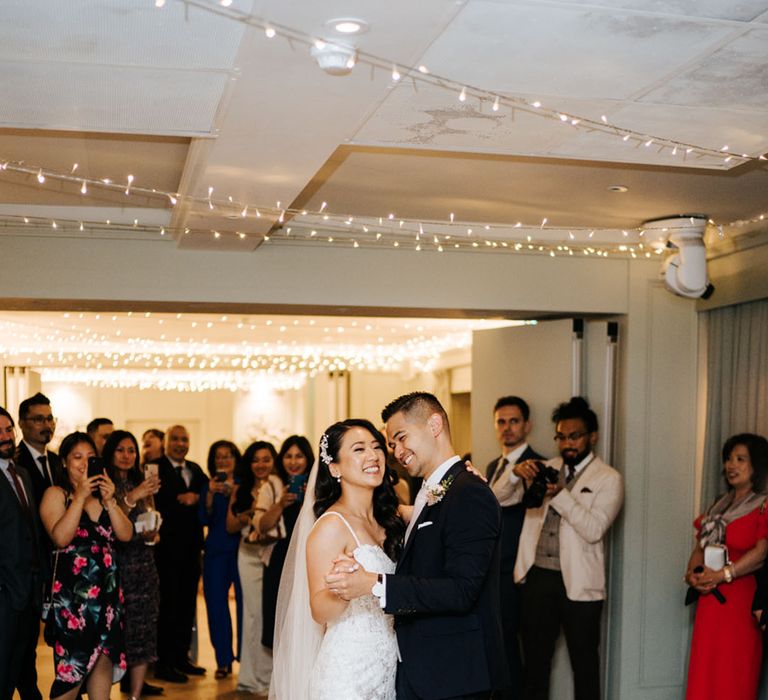 Bride and groom first dance at Bingham Riverhouse with bride in an embellished wedding dress and groom a navy suit 