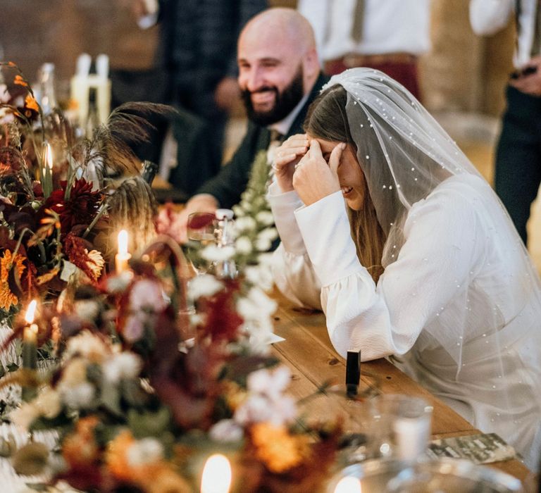 Bride laughs on her wedding day whilst wearing Luna Bea bridal gown complete with pearl veil