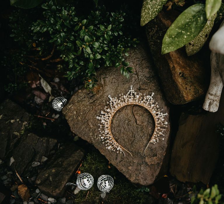 Bejewelled wedding headpiece and disco ball earrings laid outside for Wellbeing Farm wedding 